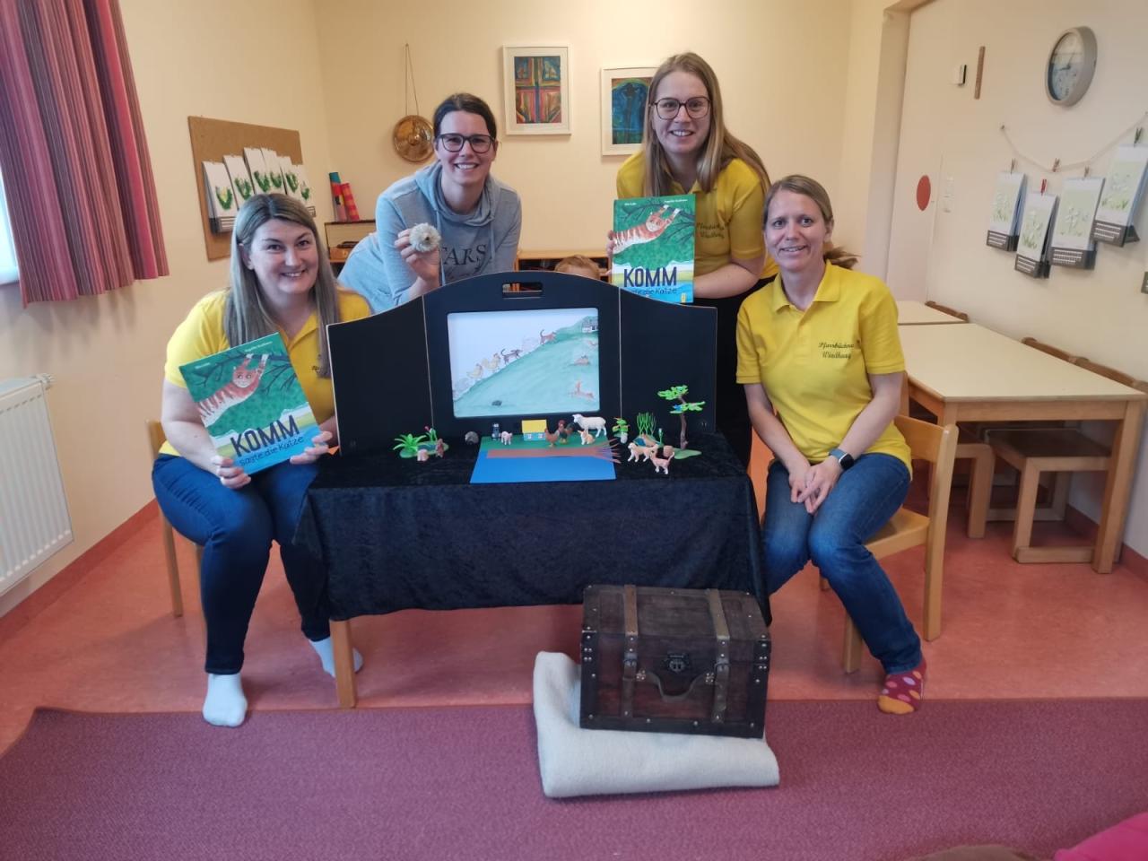 Vier Personen mit einer Buchstartbühne